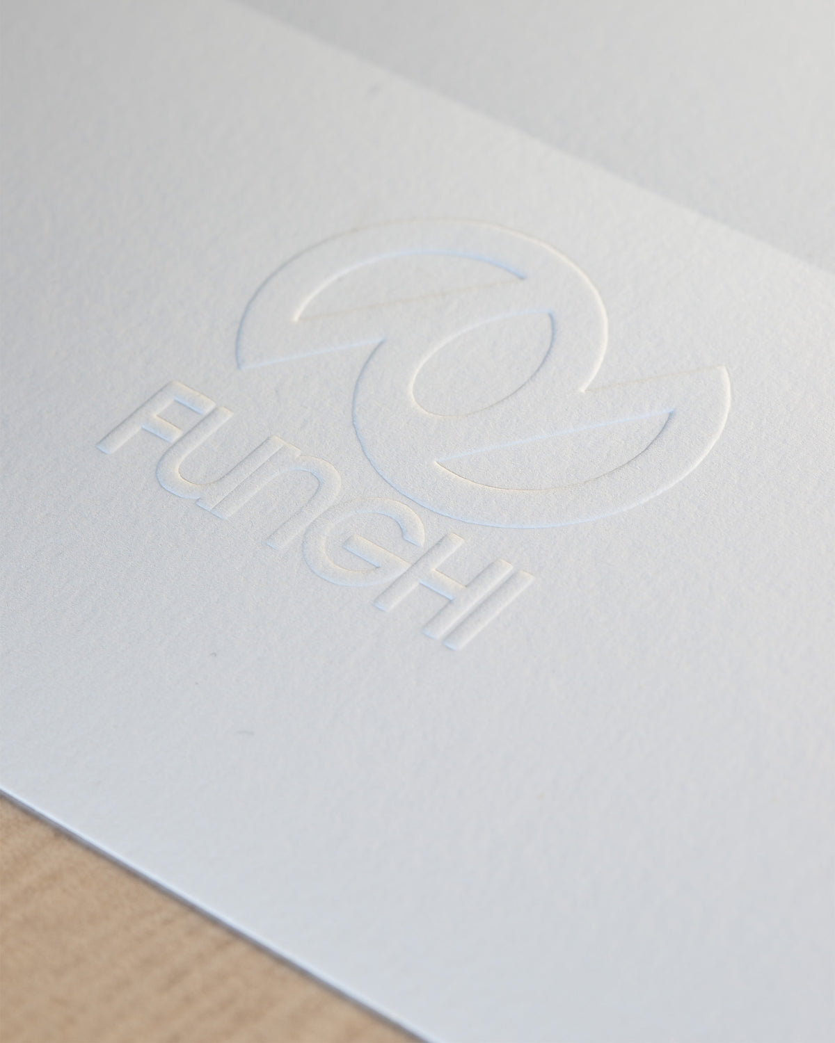 Detail of the studio's FUNGHI blind emboss, pressed into the paper margin.